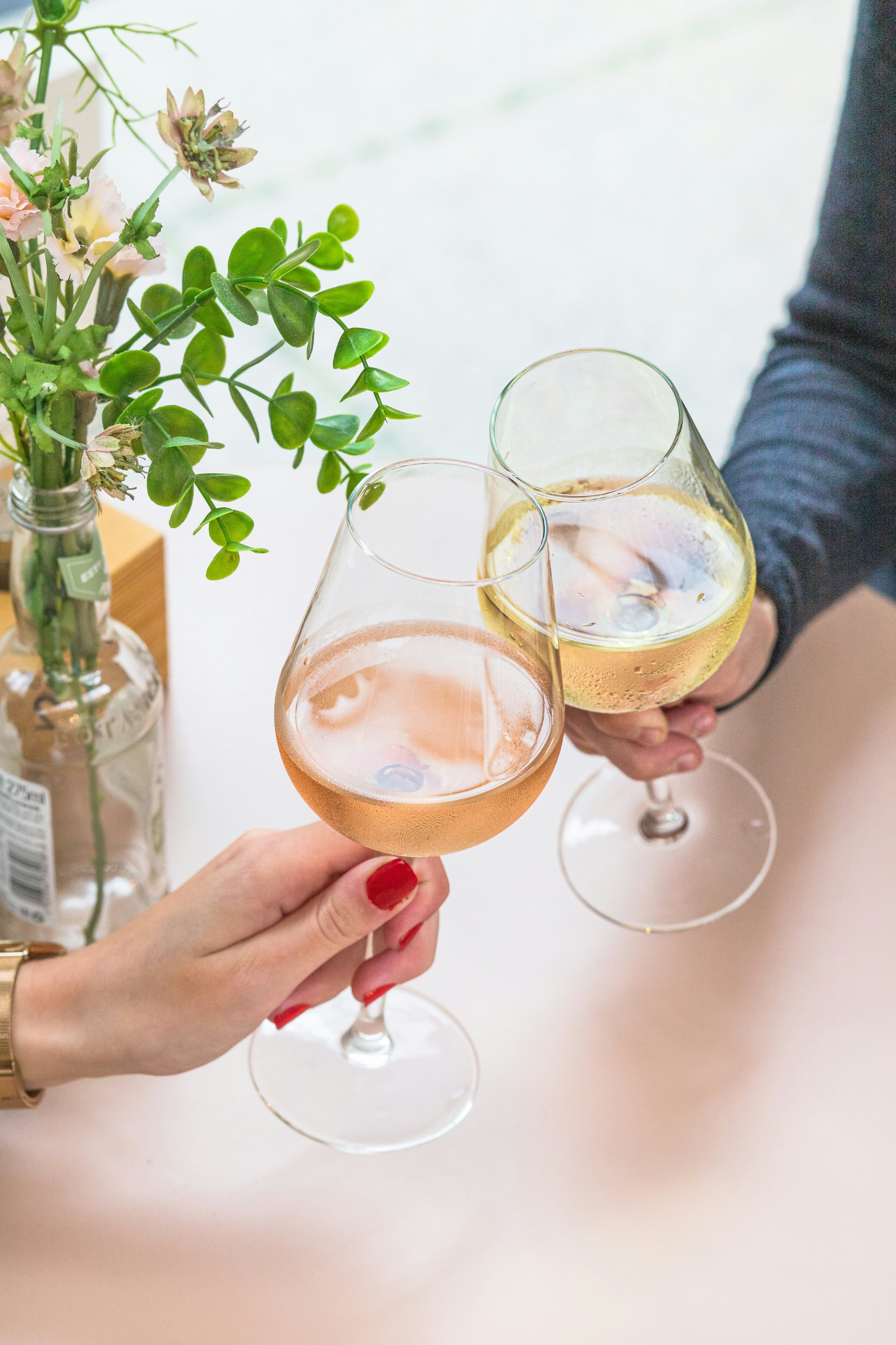 Two wine glasses clinking in a toast